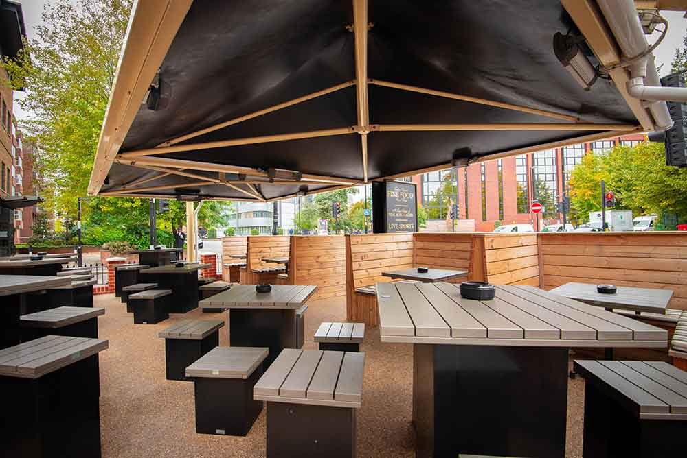 The covered outdoor seating at The Bedford Tavern: wooden benches under a large canopy