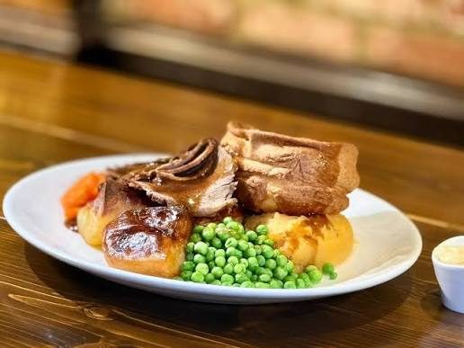 A Sunday roast at The Black Bull: sliced lamb with a Yorkshire pudding, roast potatoes, peas, carrots and gravy