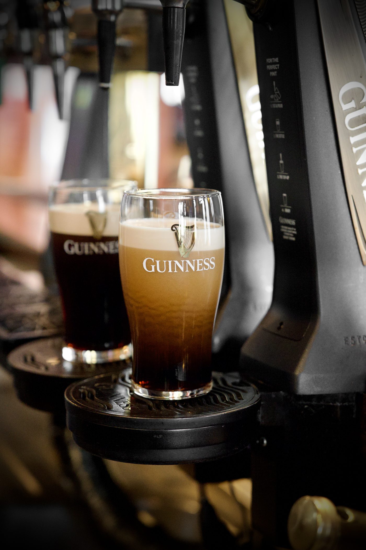 Two pints of Guinness settling under the fount
