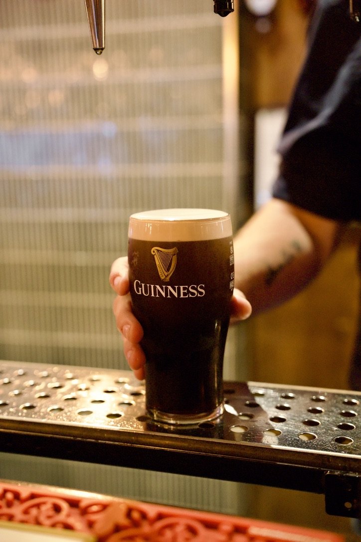 A pint of Guinness being set down on the bar top