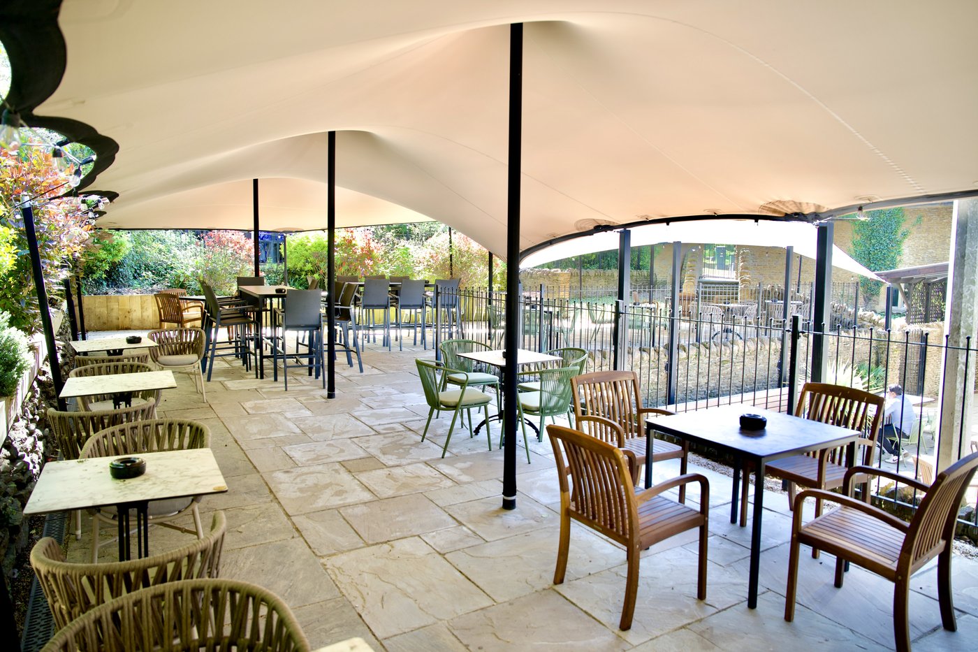 The Top Balcony: tables and chairs under a canopy, looking out over the garden