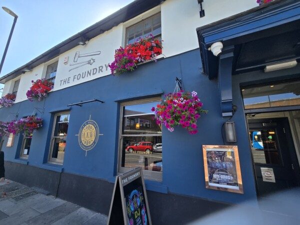 The Foundry's blue frontage with its hammer-and-tongs sign and window boxes of red flowers