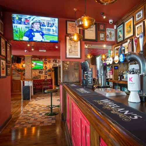 The red bar at Whelan's Kingston, branded taps and screens showing sport