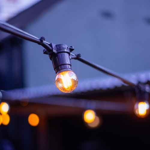 String lights over the garden patio at dusk