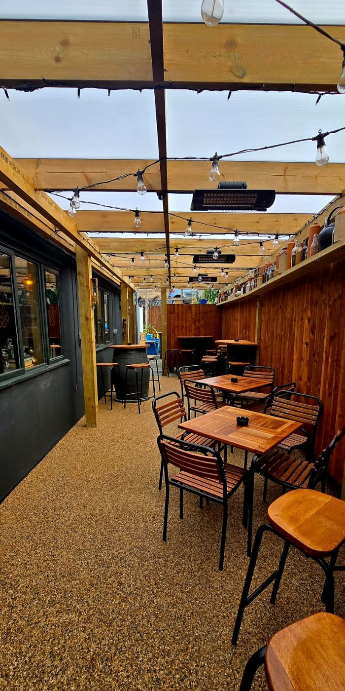 The covered beer garden, wooden tables under a timber and glass roof